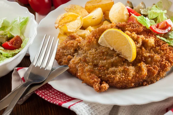 Breaded viennese schnitzel with baked potatoes — Stock Photo, Image