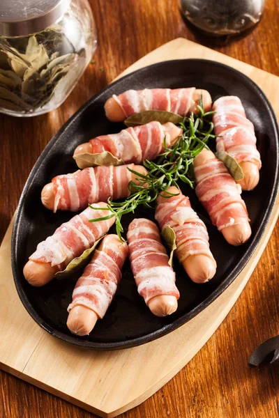 Mini saucisses crues enveloppées dans du bacon fumé — Photo
