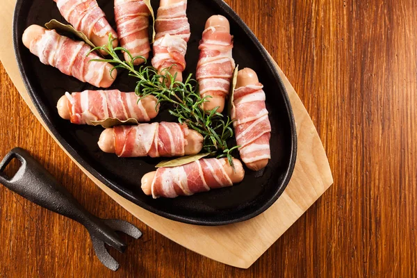 Mini salsichas cruas embrulhadas em bacon defumado — Fotografia de Stock