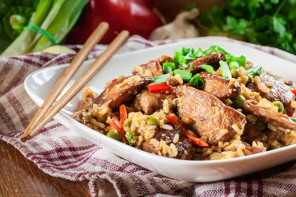 Arroz frito com frango e legumes servidos em um prato — Fotografia de Stock