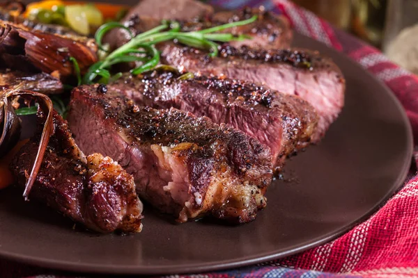 Slices of beef steak served with baked artichoke — Stock Photo, Image