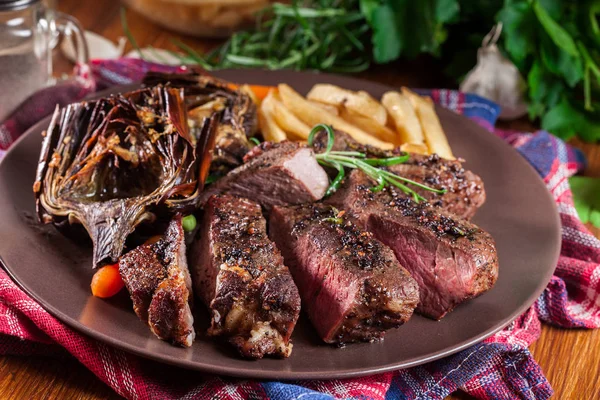 Slices of beef steak served with baked artichoke — Stock Photo, Image