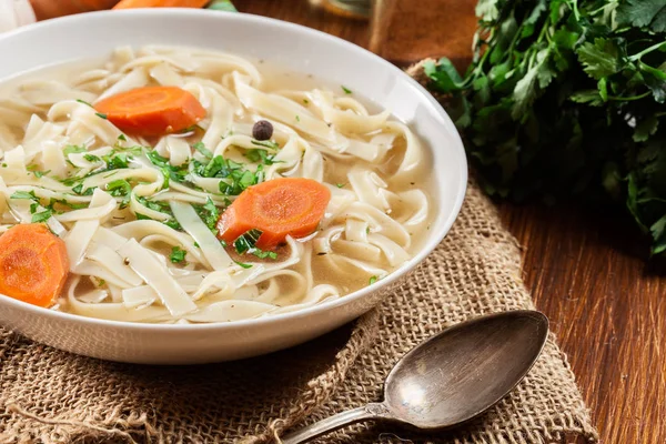 Tasty meat broth with noodles, carror and parsley — Stock Photo, Image