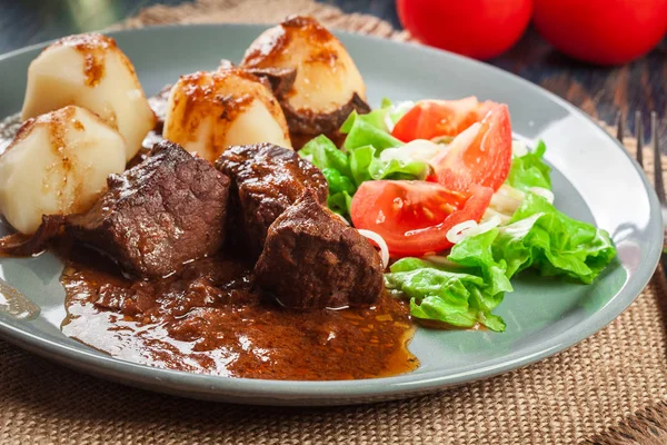 Fläsk köttgryta serveras med potatis och grönsakssallad — Stockfoto