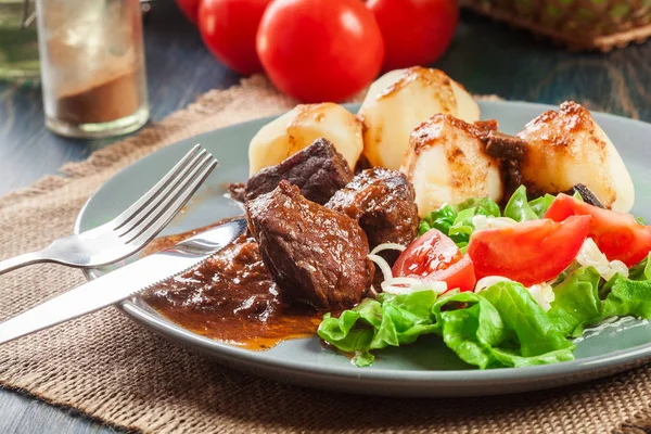 Stufato di carne di maiale servito con patate e insalata di verdure — Foto Stock