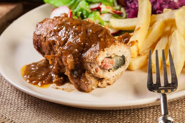 Schweineroulade mit Pommes mit Salat — Stockfoto