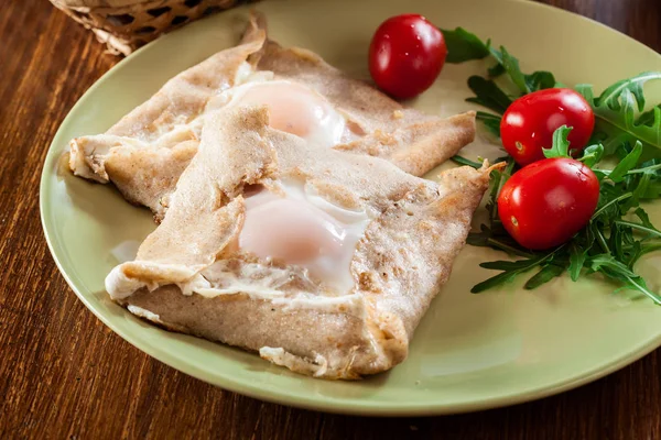 Crêpes mit Schinken, Käse und pochiertem Ei auf einem Teller — Stockfoto