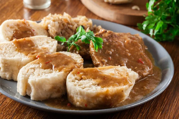 Pork loin in gravy with bread dumplings and sauerkraut — Stock Photo, Image