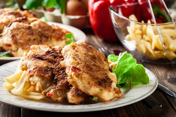 Medallones de pollo con pimientos rojos servidos con papas fritas — Foto de Stock