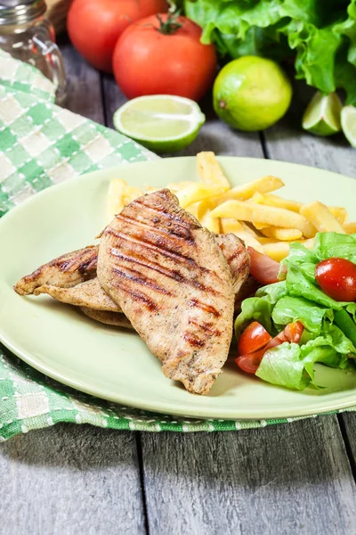 Seios de frango grelhados servidos com batatas fritas — Fotografia de Stock