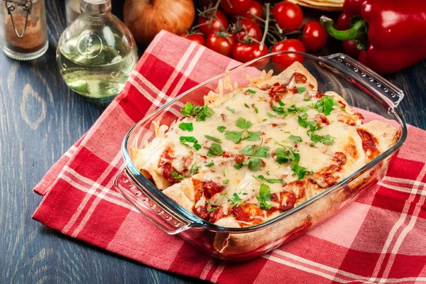 Enchiladas mexicanas tradicionales con carne de pollo, salsa de tomate picante y queso en plato resistente al calor — Foto de Stock