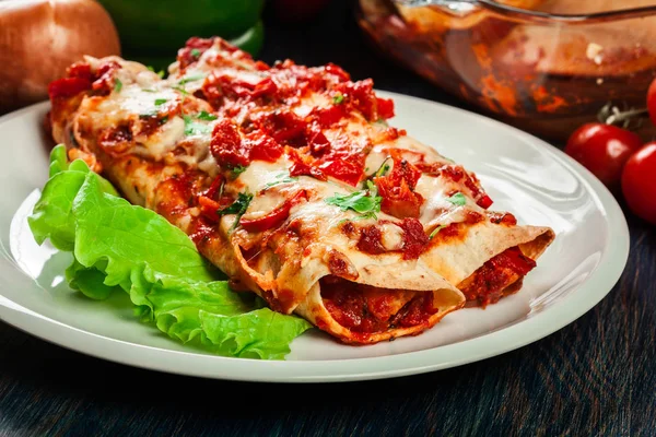Tradiční mexické enchiladas s kuřecím masem, pikantní rajčatovou omáčkou a sýrem na talíři — Stock fotografie