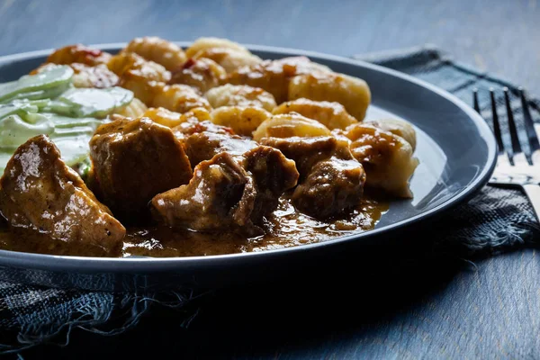 Italian potato dumplings with stew and cucumber salad — Stock Photo, Image