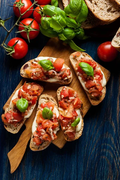 Bruschetta italiana con tomates asados, queso mozzarella y — Foto de Stock