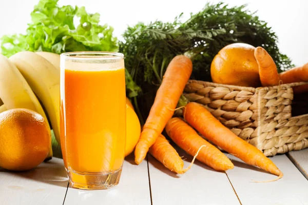 Vaso Zumo Frutas Con Naranja Zanahorias Plátano Sobre Una Mesa —  Fotos de Stock