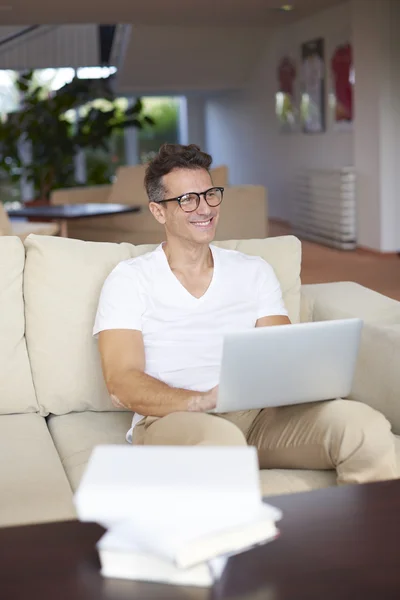 Muž sedí doma a pracovat — Stock fotografie