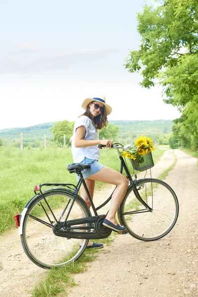 Mujer joven empujando su bicicleta —  Fotos de Stock