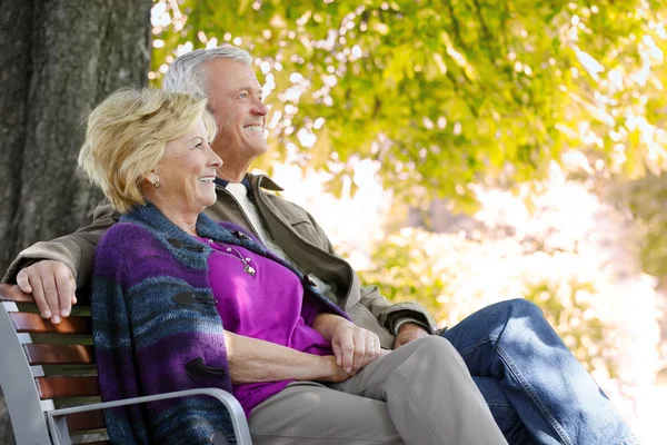 Par som sitter på en bänk — Stockfoto