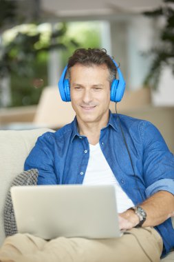  Evde dizüstü bilgisayar kullanan bir adam 