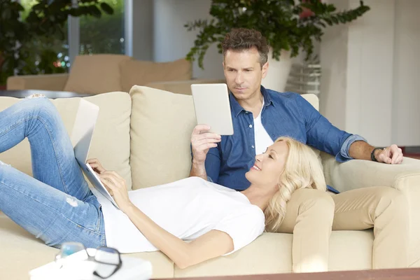 Kobieta za pomocą laptopa i człowiek za pomocą tabletu — Zdjęcie stockowe