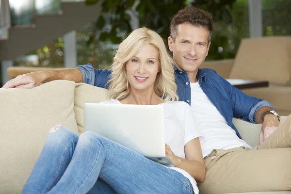Couple relaxing at home on the sofa — Stock Photo, Image
