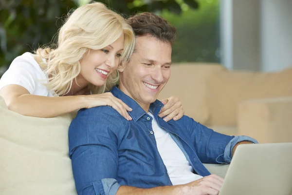 Happy couple using a laptop — Stock Photo, Image