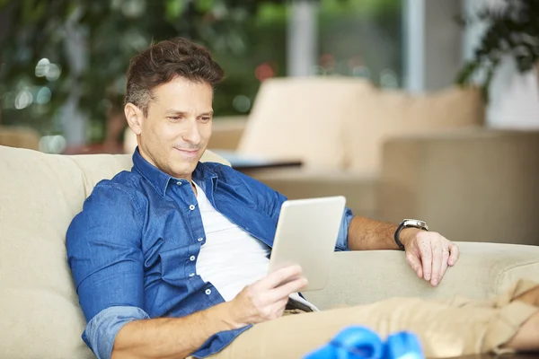 Uomo sorridente utilizzando tablet digitale — Foto Stock