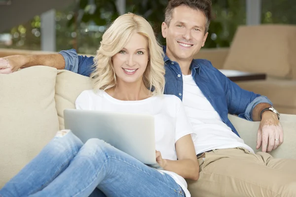 Casal feliz com laptop em casa — Fotografia de Stock