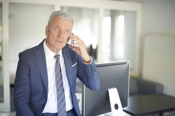 Homme d'affaires au bureau avec téléphone — Photo