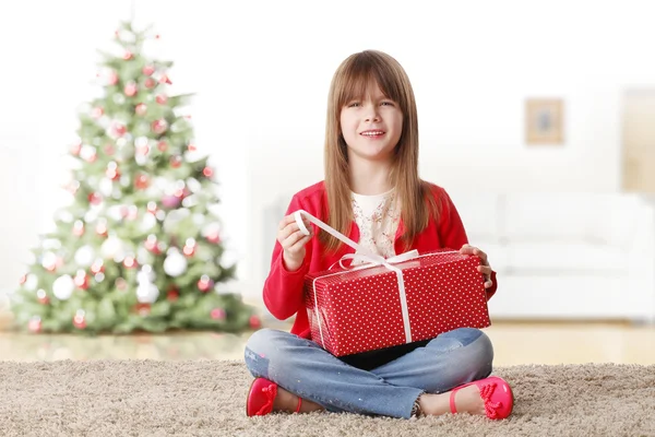 Девушка открывает свой рождественский подарок — стоковое фото