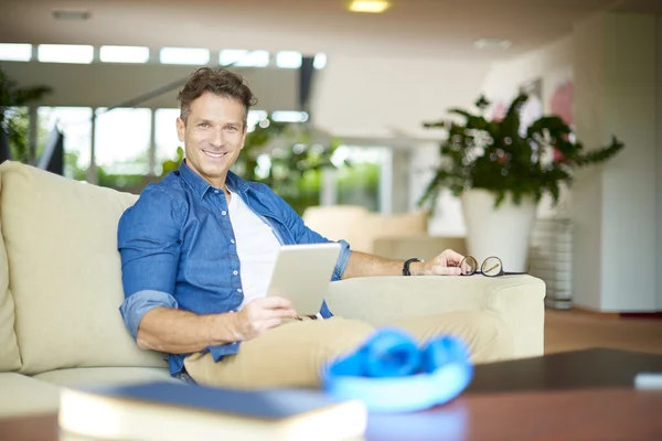 Homem usando seu tablet enquanto relaxa — Fotografia de Stock