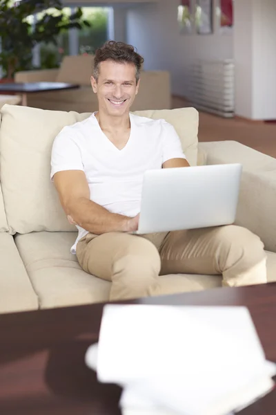 Homme occasionnel en utilisant son ordinateur portable tout en étant assis — Photo