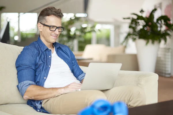 Man using his laptop while sitting — Stockfoto