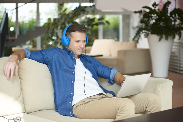 Homme avec son ordinateur portable écouter de la musique — Photo
