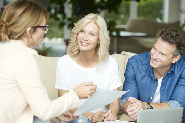 Geschäftsfrau berät sich mit Paar mittleren Alters — Stockfoto