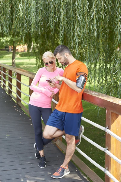 Junges Paar checkt Lauf-App — Stockfoto