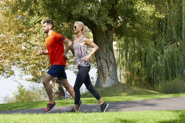 Casal correndo juntos ao ar livre — Fotografia de Stock