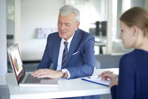 Hombre de negocios consultando con su joven asistente —  Fotos de Stock