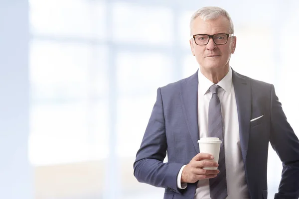 一杯のコーヒーを保持している自信を持っているビジネスマン — ストック写真
