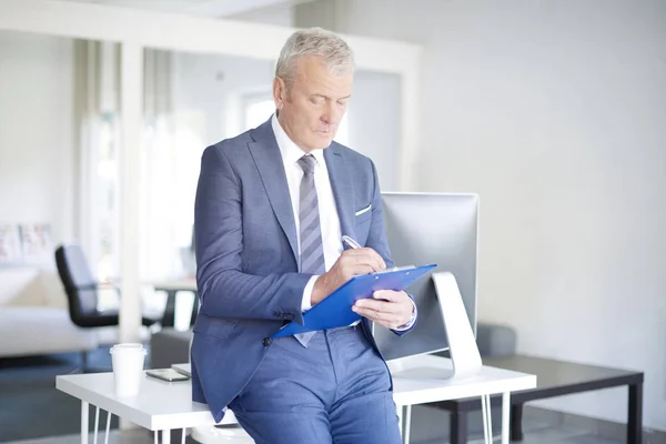 Senior businessman holding clipboard — Stock Photo, Image