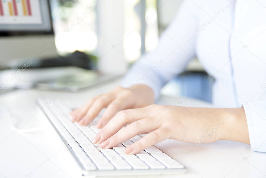 woman's hands typing on her computer 