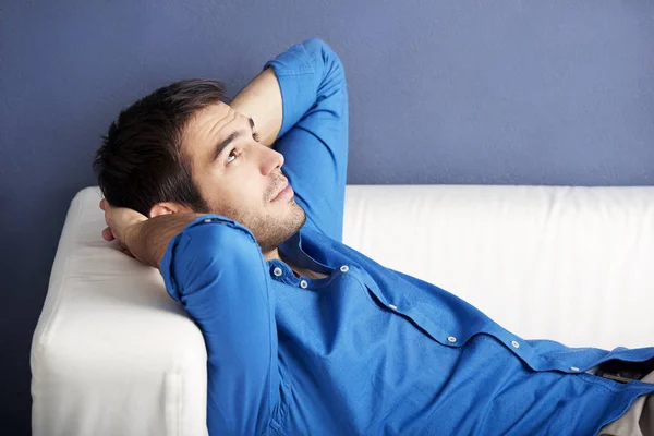 man lying on couch and relaxing.