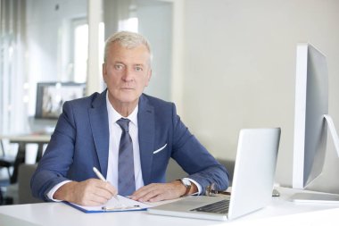 onun iş istasyonunda oturan Yöneticisi 