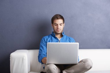 onun laptop ile kanepede oturan adam