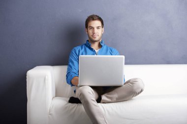 onun laptop ile kanepede oturan adam