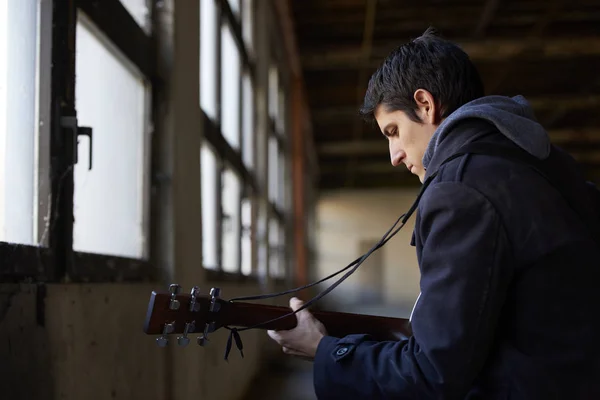 Uomo che pratica sulla sua chitarra acustica . — Foto Stock