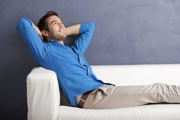 Young man sitting on the sofa — Stock Photo, Image