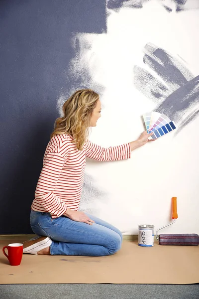 Frau sitzt vor der Wand — Stockfoto