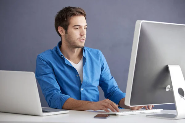 Νεαρός άνδρας, χρησιμοποιώντας τον υπολογιστή του — Φωτογραφία Αρχείου