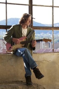 onun elektro gitar üzerinde pratik müzisyen.